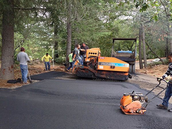 Richs' Paving Contractors crew paving a driveway in wooded area in Santa Rosa